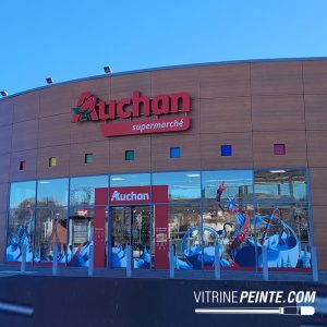 Décoration saisonnière de Noël en centre commercial avec sapin monumental et illuminations festives.