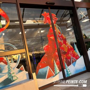 Décoration de Noël d’une porte automatique de centre commercial avec une hotte géante du Père Noël