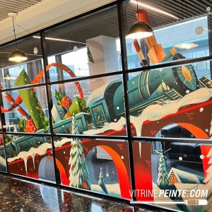 Peinture sur vitrine de la locomotive géante du train du Père Noël « Pôle Express », décoration de Noël réalisée à la main pour vitrine de magasin.