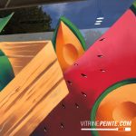 Motif de pastÚques tendance peint directement sur une vitrine de magasin de fruits et légumes pour une décoration estivale et colorée.