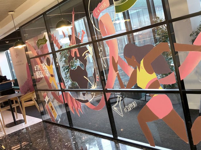 Décorateurs de vitrines transformant les surfaces vitrées en supports de communication pour Octobre Rose.