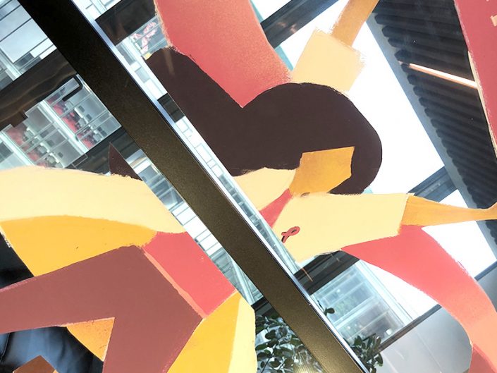 Habillage de vitrine pour Octobre Rose avec peinture sur vitre, décoration florale et ruban rose géant.