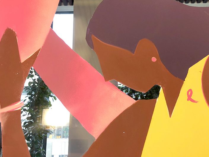 Décorateurs de vitrines transformant les surfaces vitrées en supports de communication pour Octobre Rose.