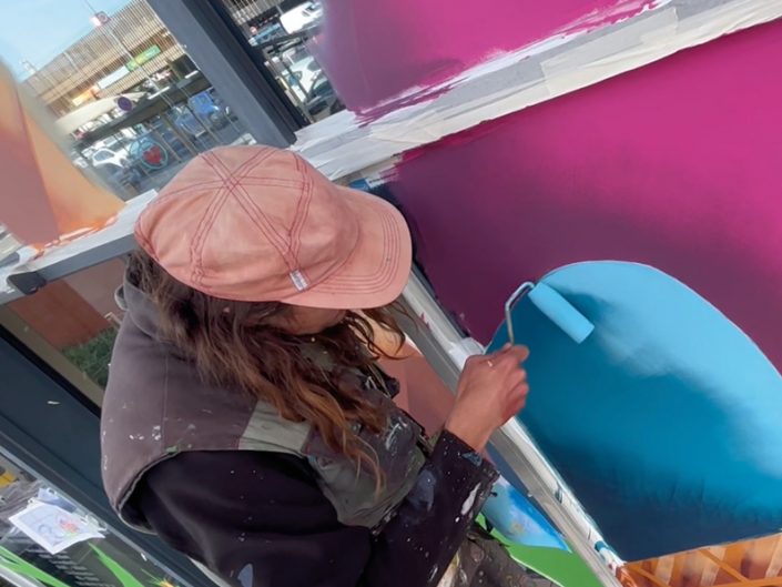 Peintre en décor réalisant une peinture sur vitrine à la main