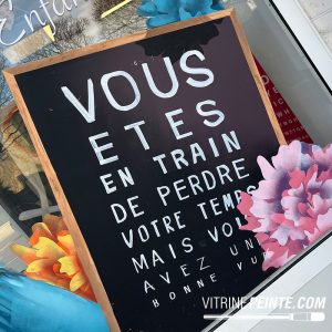 Merchandising de vitrine pour opticien avec test optique géant sur tableau noir XXL, une décoration originale qui capte le regard et dynamise le point de vente. Décoration et merchandising de vitrine d'opticien avec tableau noir format XXL et test de vue