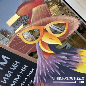 Décoration commerciale de Pâques pour opticien avec poule géante portant des lunettes, création visuelle originale destinée au merchandising et à l’attractivité de la vitrine.