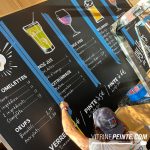 Lettrage peint à la craie sur tableaux noirs de restaurant, avec menus, tarifs et illustrations décoratives