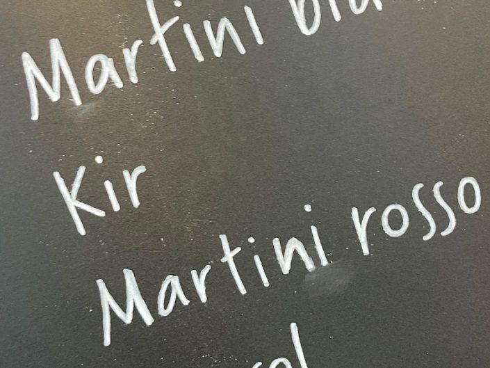 Menu sur tableau noir décoré à la craie avec lettrage artistique, illustrations et présentation des tarifs