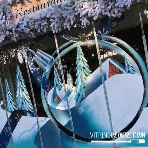 DĂ©coration de vitrine dâhiver Ă©co-responsable peinte directement sur la vitre, avec un dĂ©cor de NoĂ«l artistique et sans Ă©clairage Ă©lectrique.