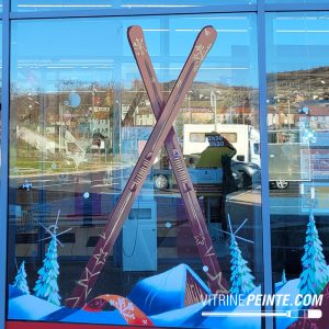 Paire de skis anciens en bois vintage, utilisée comme décoration peinte sur la vitrine d'un magasin au style rétro.
