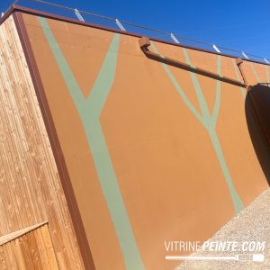 Habillage peint d'un bâtiment avec logo et identité visuelle sur façade
