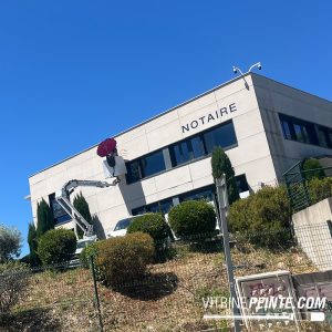 Réalisation d’une enseigne peinte à la main en grand format, travail artisanal de lettrage peinture sur bardage composite.