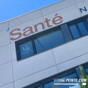 Enseigne XXL finalisée avec lettrage peinture peint à la main, une signalétique extérieure personnalisée sur bardage composite.