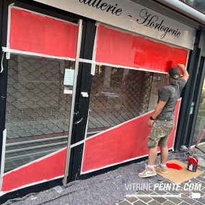sticker déstockage géant en peinture sur vitrine de magasin
