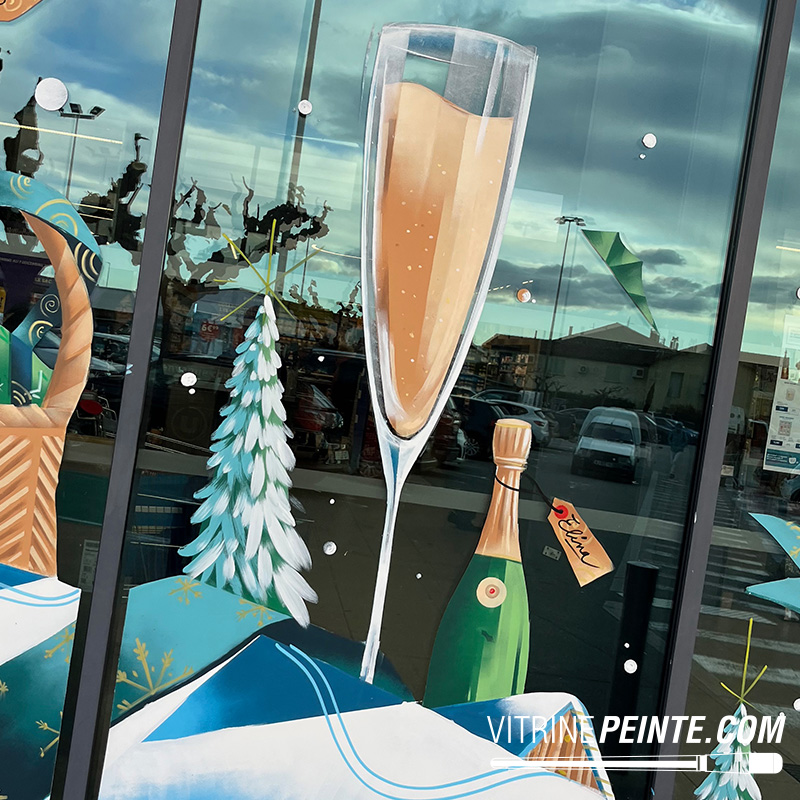 Décoration de vitrine avec une immense bouteille de champagne et un verre flûte XXL, création artistique sur vitrine pour une ambiance festive et spectaculaire.